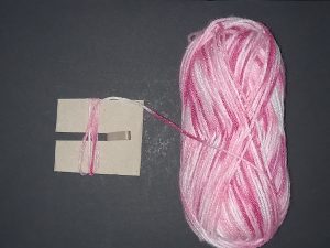 Spider Pompom Step 3: Start wrapping wool round the end with the slit.